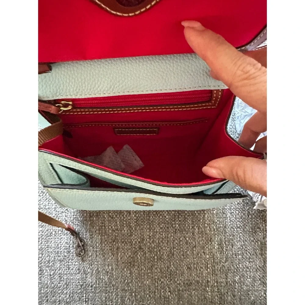 This is a Dooney & Bourke Pebble Grain East/West Flap Crossbody in a light blue